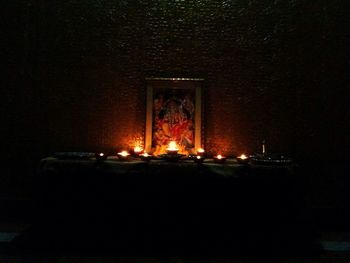 Lit candle in dark room