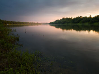 Scenic view of lake against sky at sunset