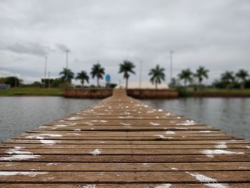 Surface level of pier over lake against sky