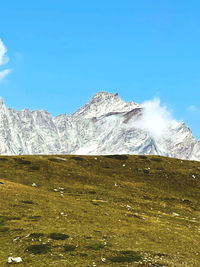 Scenic view of snowcapped mountains against blue sky