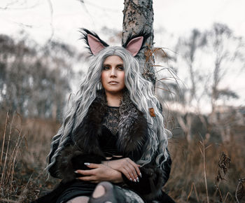 Young woman standing against tree during autumn