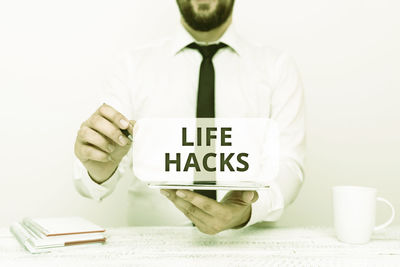 Midsection of man holding camera with text on white background