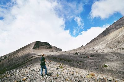 Full length of woman standing on mountain against sky