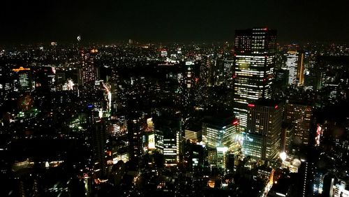 Illuminated cityscape against sky at night