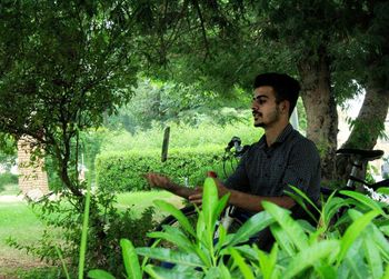 Young man sitting in forest