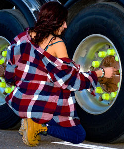 Full length of young woman by tires