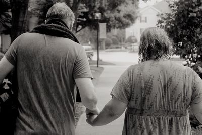 Rear view of people walking on road