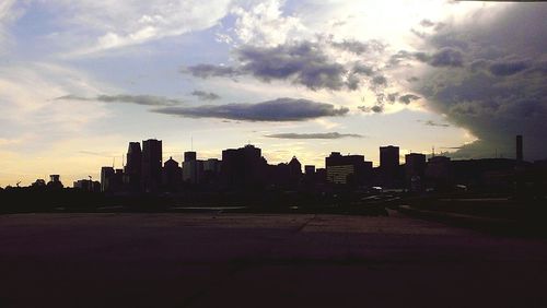 Buildings in city against cloudy sky