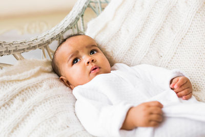 Portrait of cute baby lying on bed