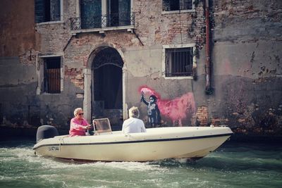 People in boat against canal