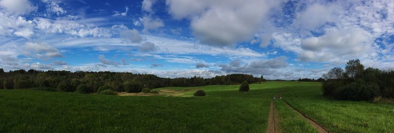 Scenic view of grassy field against cloudy sky