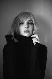 Close up portrait of a woman with pink hair and a black sweater on the background