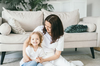 A mother tenderly kisses her four-year-old daughter.