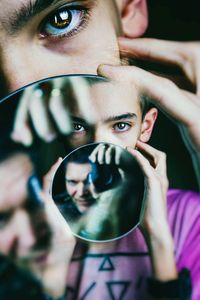 Close-up portrait of young man holding camera