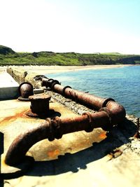 Close-up of rusty metal chain against sky