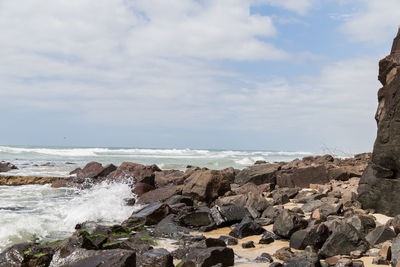 Rocks on beach against sky