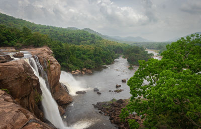 Athirapally waterfall with cloudy sky and green forests of the western ghat range