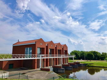 Building by lake against sky