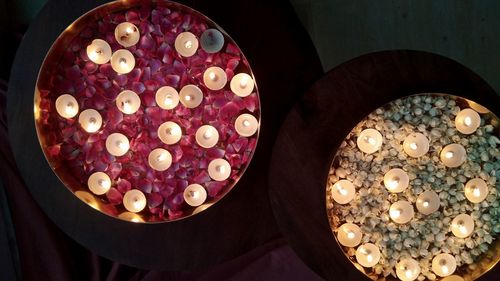 High angle view of illuminated candles in bowl