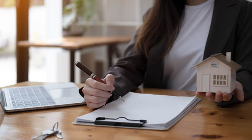 Midsection of woman using laptop on table