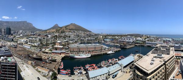 High angle view of city buildings against blue sky