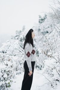 Woman standing on snow against sky
