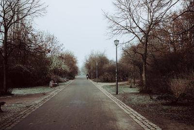 Road amidst trees against clear sky