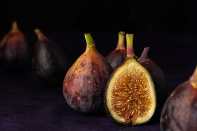 Close-up of figs on table against black background