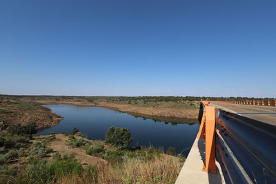 Scenic view of bridge and river against clear blue sky