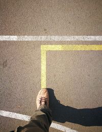 Low section of man standing on road