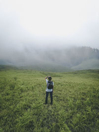 Rear view of woman on field against sky