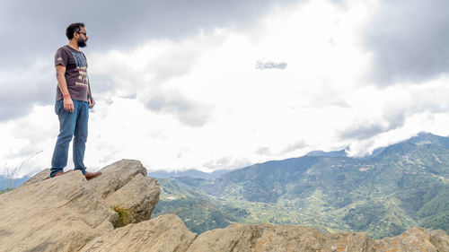 Full length of man standing on rock against sky