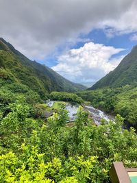 Scenic view of river by mountains against sky