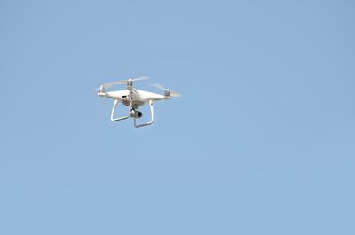 Low angle view of airplane against clear blue sky