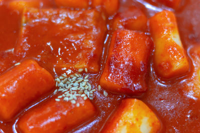 Spicy korean dish topokki of rice dumplings close up top view.