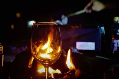 Close-up of wineglass on lit candle