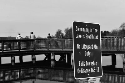 Information sign on bridge against sky