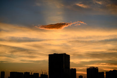 Silhouette buildings against sky during sunset