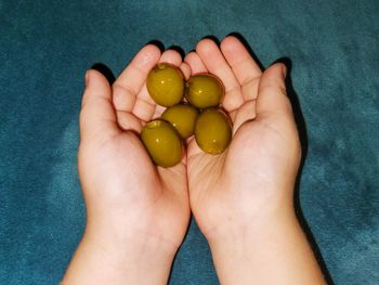 A child holding green olives - a boy's favorite snack