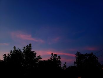 Low angle view of silhouette trees against sky at sunset