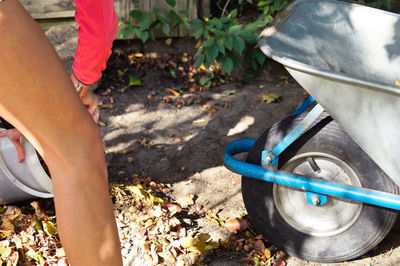 Cropped image of woman by wheelbarrow