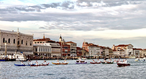 Boats in canal against buildings in city