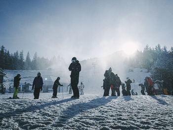 People on snow covered mountain against sky