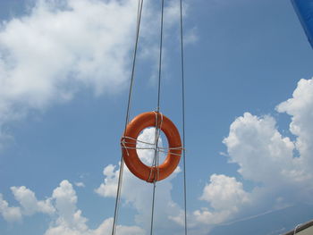 Low angle view of clock on rope against sky