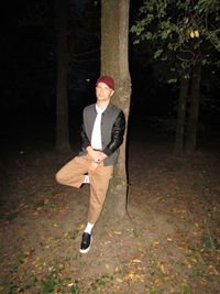 Full length portrait of man standing against tree