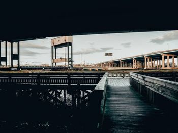 Bridge over river in city against sky