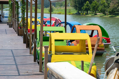 Empty chairs and tables by lake