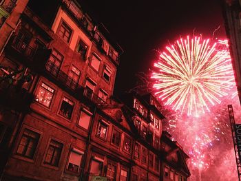 Low angle view of illuminated fireworks against sky at night