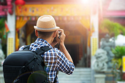 Rear view of man standing on mobile phone