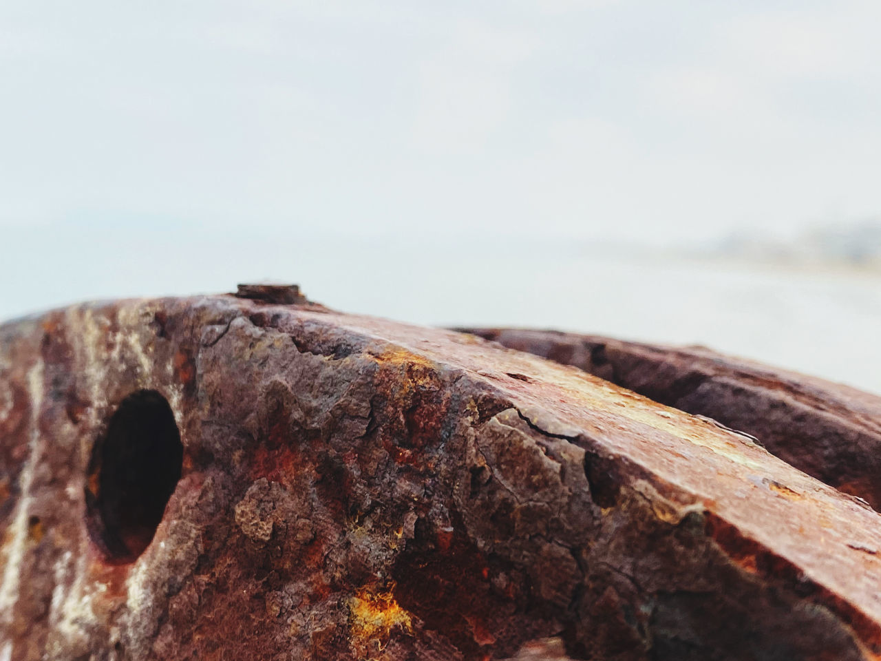 CLOSE-UP OF RUSTY METAL ON ROCK